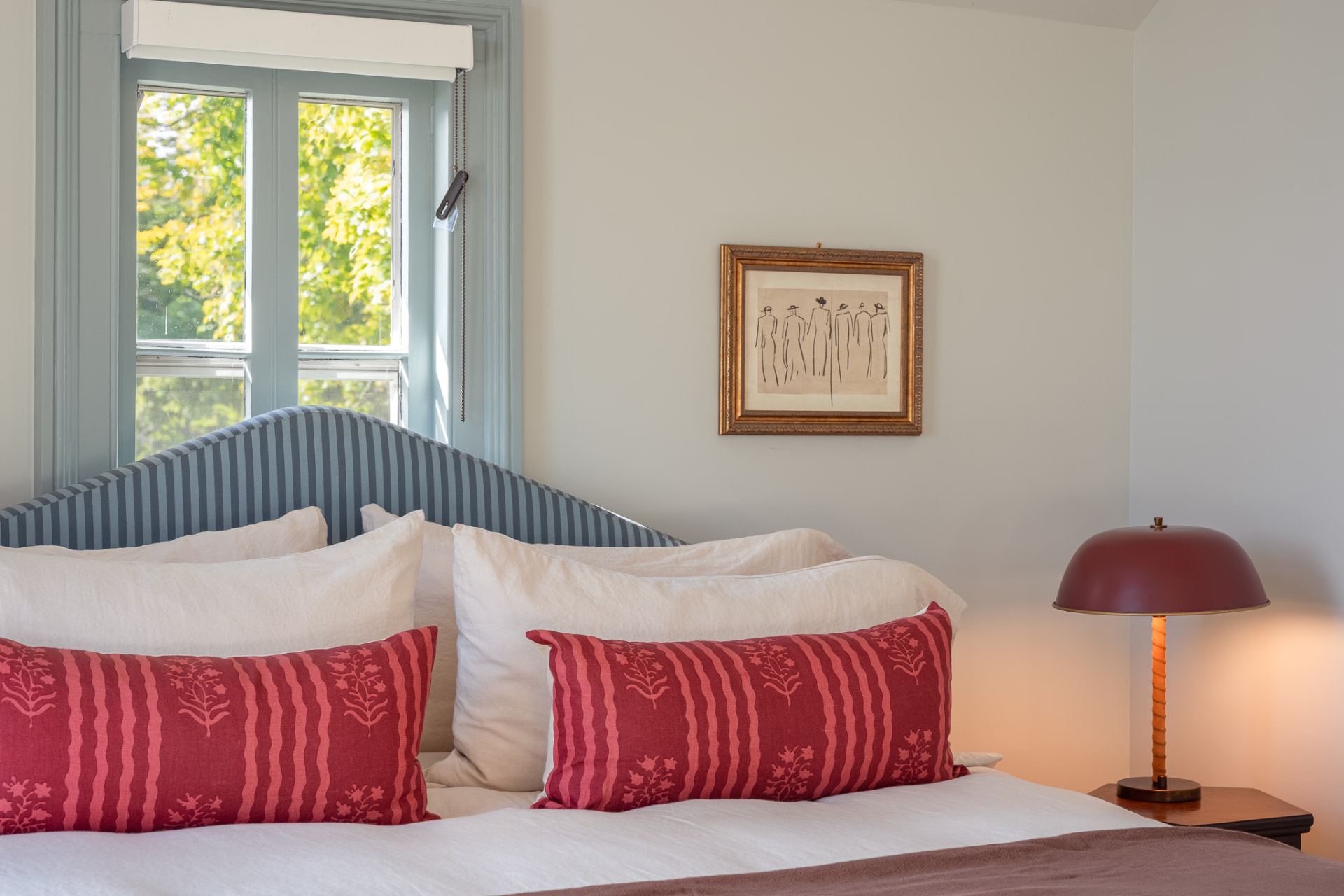 Bedroom detail with striped headboard and red pillows