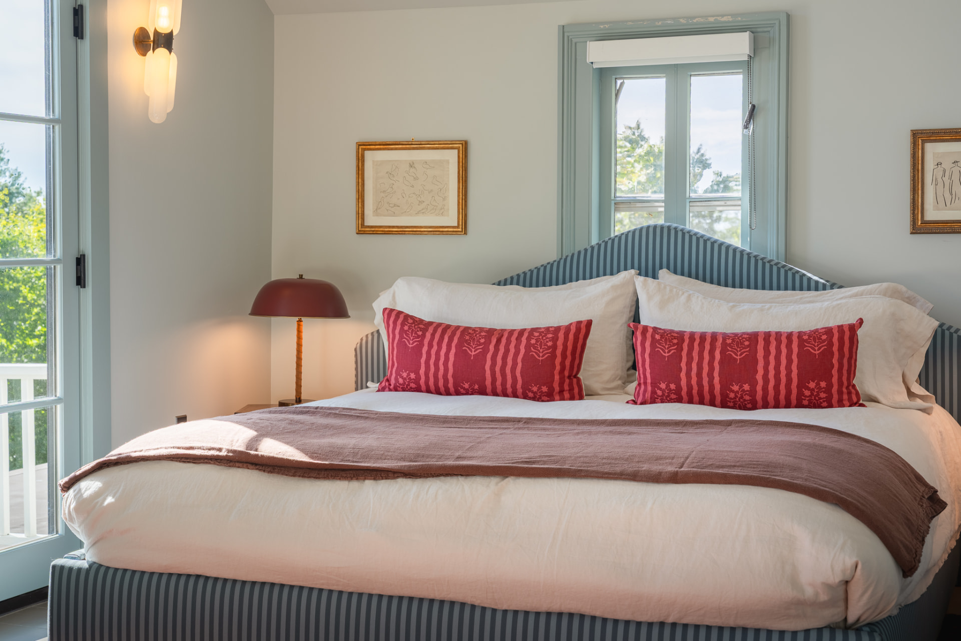 Guest bedroom with arched windows and striped bed
