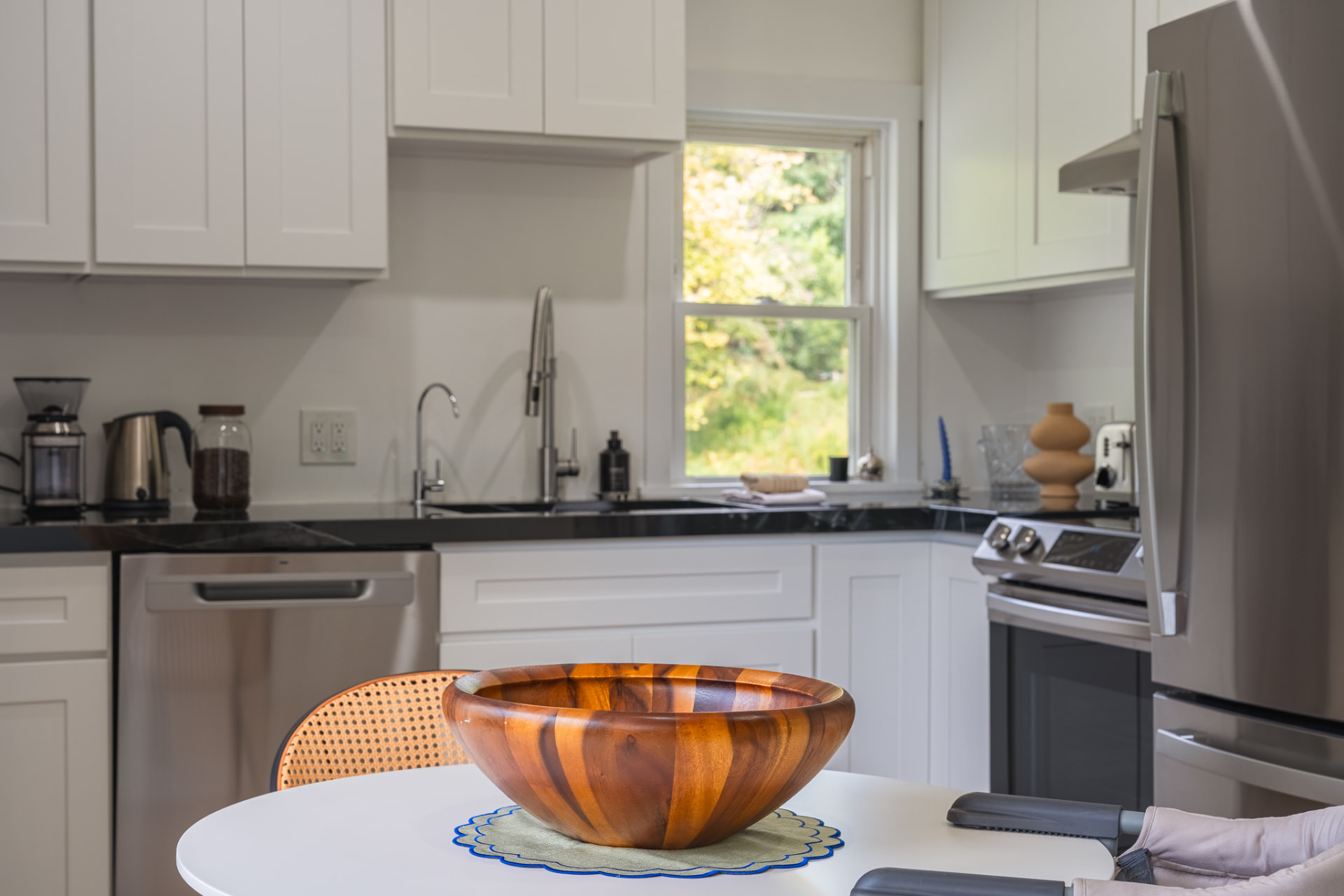Cabin kitchen with white cabinets and a wooden bowl on the table