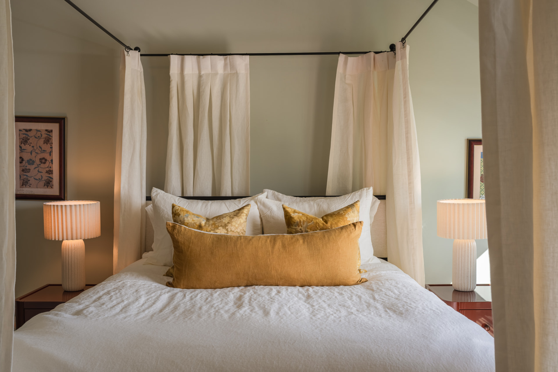 Canopy bed dressed in linen with amber pillows